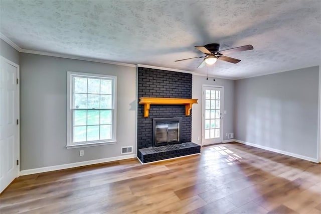 516 Jordan Dr NW, Tucker, GA 30084 - unfurnished living room with wood finished floors, a ceiling fan, a brick fireplace, a textured ceiling, and ornamental molding
