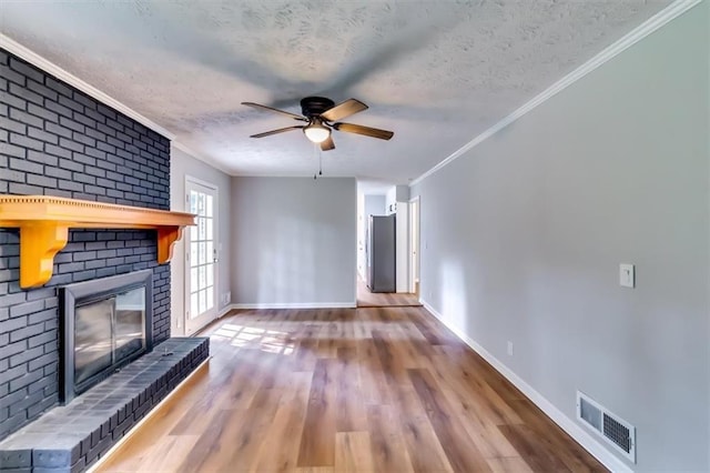 516 Jordan Dr NW, Tucker, GA 30084 - unfurnished living room featuring a textured ceiling, a brick fireplace, a ceiling fan, wood finished floors, and ornamental molding