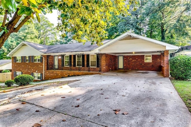 516 Jordan Dr NW, Tucker, GA 30084 - ranch-style home with driveway, brick siding, an attached carport, and covered porch