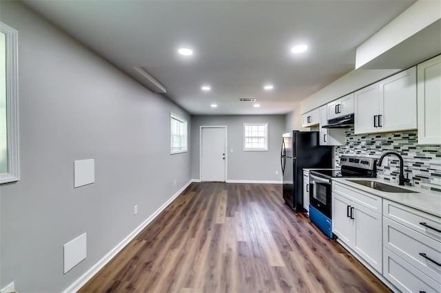 516 Jordan Dr NW, Tucker, GA 30084 - kitchen featuring stainless steel electric range, under cabinet range hood, dark wood-style floors, tasteful backsplash, and white cabinetry