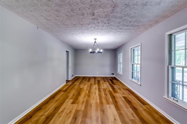 516 Jordan Dr NW, Tucker, GA 30084 - unfurnished room featuring a chandelier, wood finished floors, and a textured ceiling