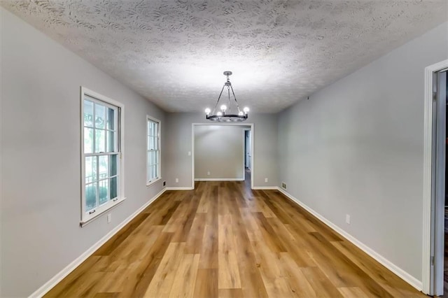 516 Jordan Dr NW, Tucker, GA 30084 - unfurnished dining area with light wood finished floors, a chandelier, and a textured ceiling