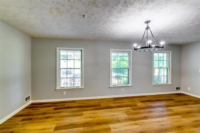 516 Jordan Dr NW, Tucker, GA 30084 - unfurnished room featuring a textured ceiling, a chandelier, and wood finished floors