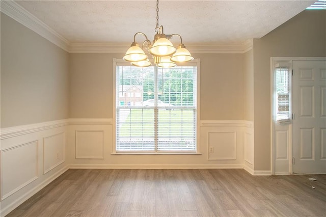 6683 Princeton Park Ct, Lithonia, GA 30058 - unfurnished dining area featuring a chandelier, healthy amount of natural light, wood finished floors, wainscoting, and a textured ceiling