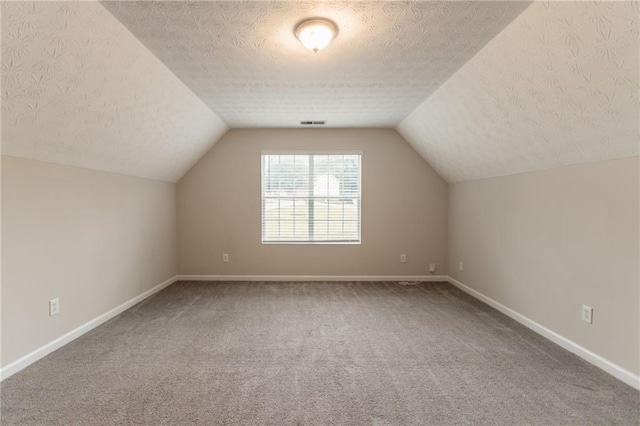 6683 Princeton Park Ct, Lithonia, GA 30058 - additional living space with carpet floors, baseboards, a textured ceiling, and vaulted ceiling