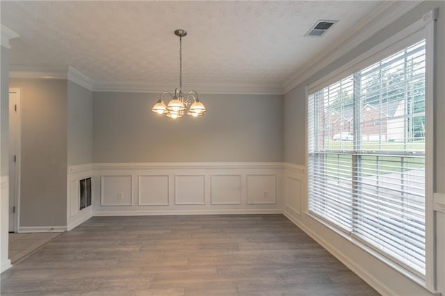6683 Princeton Park Ct, Lithonia, GA 30058 - unfurnished dining area with a chandelier, wood finished floors, a wainscoted wall, and ornamental molding
