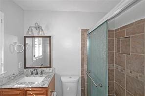 bathroom featuring vanity, a stall shower, and toilet
