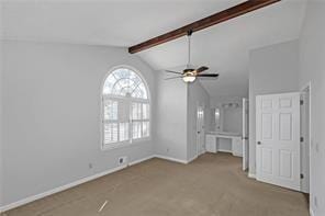 unfurnished living room featuring baseboards, vaulted ceiling with beams, carpet, and ceiling fan