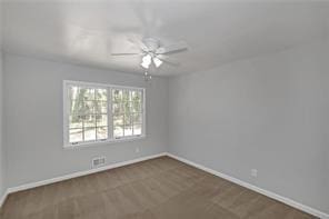 carpeted empty room with baseboards and ceiling fan