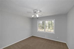 unfurnished room with a ceiling fan and baseboards