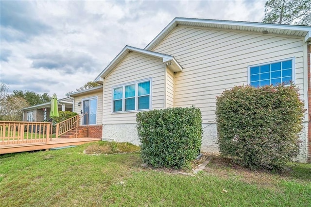 view of home's exterior with a lawn and a deck