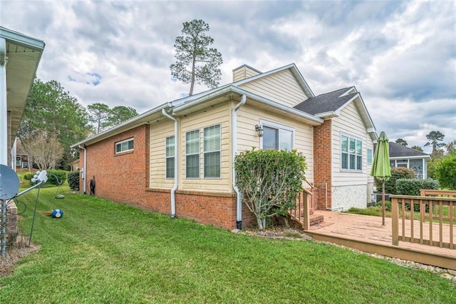 view of side of property featuring a deck and a lawn