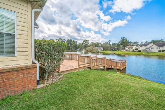 view of dock featuring a lawn and a deck with water view