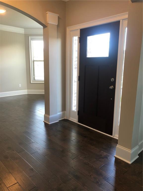 entryway featuring dark wood-type flooring and ornamental molding