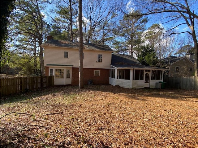 rear view of house featuring a sunroom