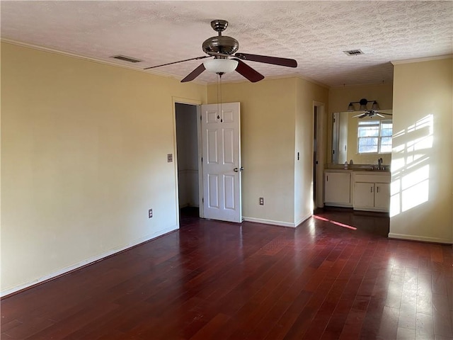 unfurnished room featuring a textured ceiling, dark hardwood / wood-style floors, and sink