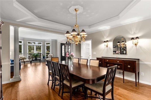 2759 Thomashire Trce, Marietta, GA 30066 - dining area featuring a chandelier, a raised ceiling, wood finished floors, decorative columns, and crown molding