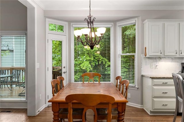 2759 Thomashire Trce, Marietta, GA 30066 - dining area featuring a chandelier, wood finished floors, healthy amount of natural light, and crown molding