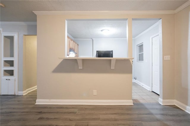 2817 Burton Rd NW, Atlanta, GA 30311 - kitchen with wood finished floors, fridge, a peninsula, crown molding, and a kitchen bar
