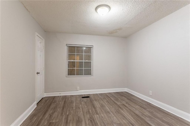 2817 Burton Rd NW, Atlanta, GA 30311 - unfurnished room with a textured ceiling, dark wood-type flooring, and baseboards