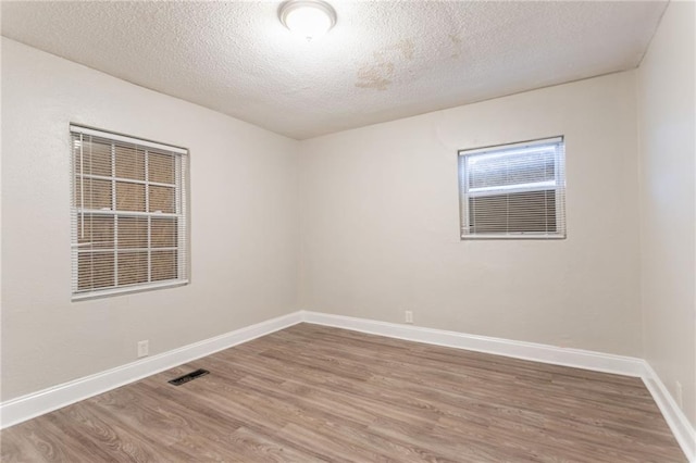 2817 Burton Rd NW, Atlanta, GA 30311 - empty room with wood finished floors, a textured ceiling, and baseboards