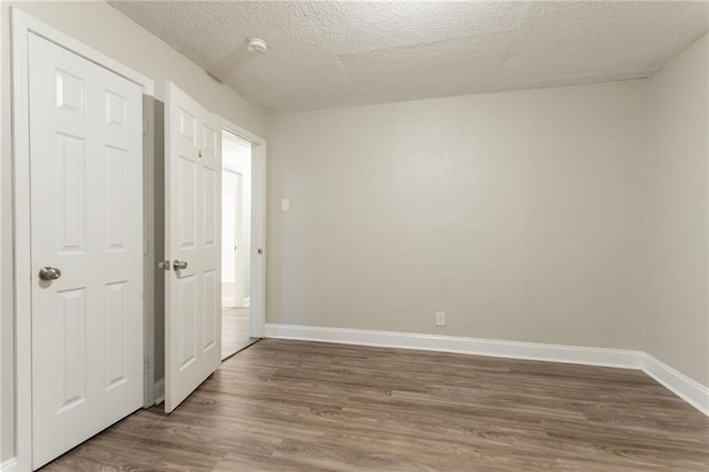 2817 Burton Rd NW, Atlanta, GA 30311 - unfurnished bedroom featuring dark wood finished floors, baseboards, and a textured ceiling