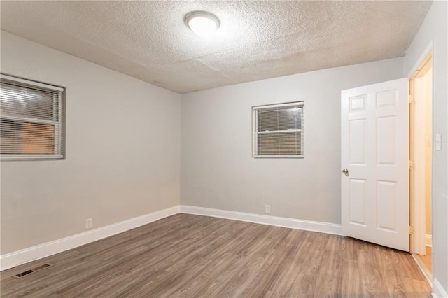 2817 Burton Rd NW, Atlanta, GA 30311 - unfurnished room featuring wood finished floors, baseboards, and a textured ceiling