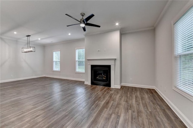 unfurnished living room featuring ornamental molding, wood finished floors, a fireplace, a ceiling fan, and recessed lighting