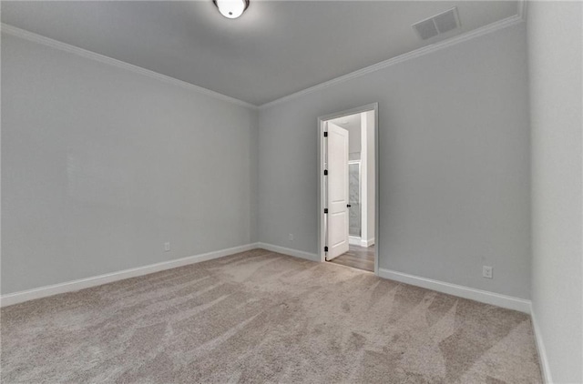 empty room with carpet flooring, ornamental molding, and baseboards