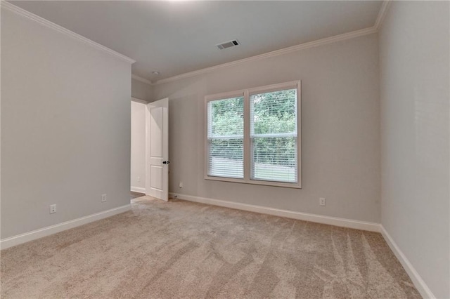 carpeted spare room featuring crown molding and baseboards