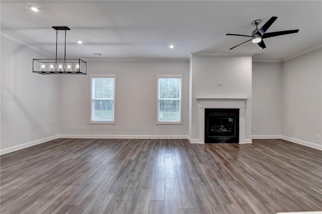 unfurnished living room featuring crown molding, wood finished floors, baseboards, a chandelier, and ceiling fan