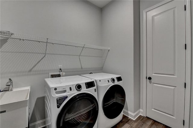 washroom with washer and dryer, dark wood-style floors, and baseboards