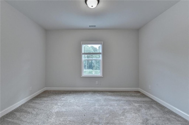 carpeted empty room featuring baseboards