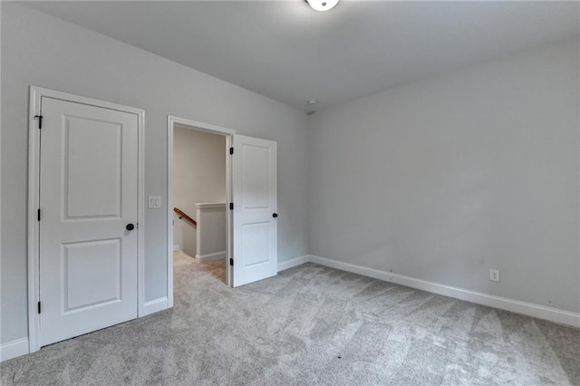 unfurnished bedroom featuring carpet floors and baseboards