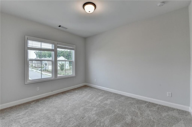 carpeted spare room with baseboards and a smoke detector