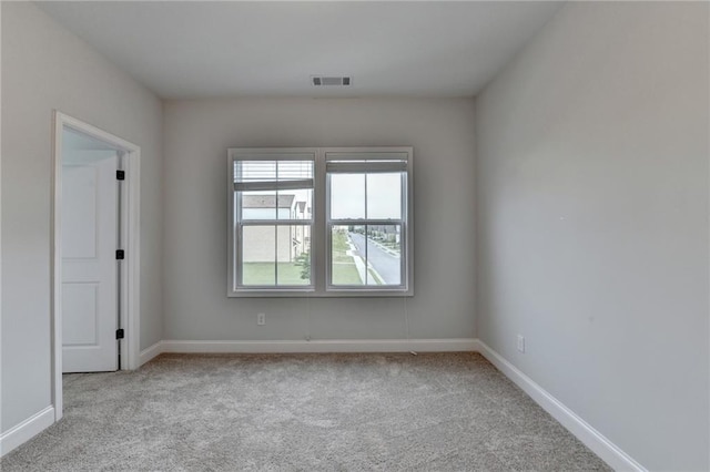 carpeted empty room featuring baseboards