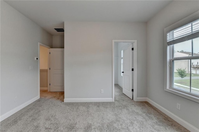 unfurnished bedroom featuring carpet flooring, baseboards, and a spacious closet