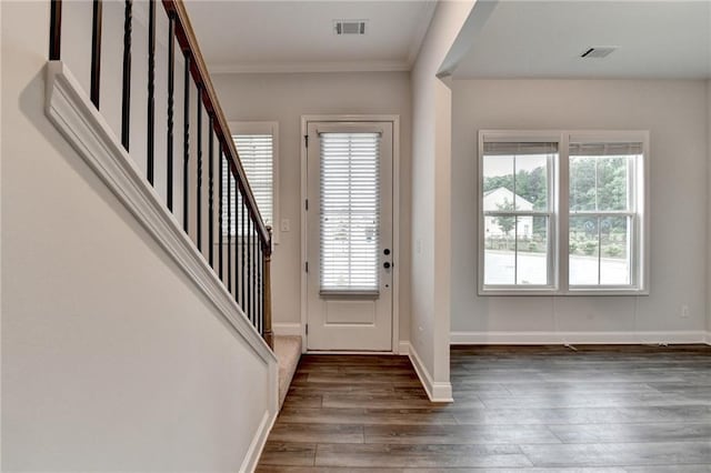 entrance foyer featuring hardwood / wood-style floors, stairway, ornamental molding, and baseboards