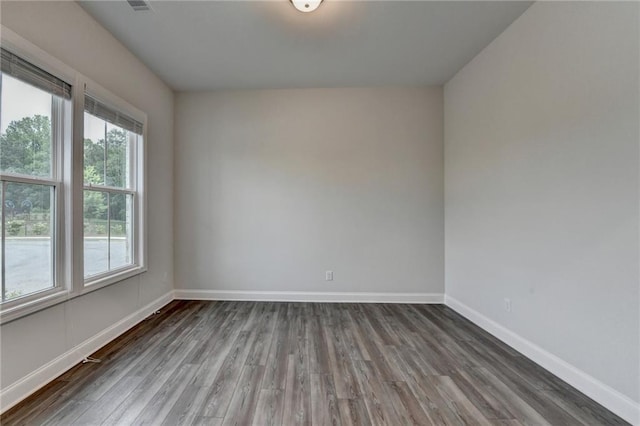 spare room with wood finished floors and baseboards