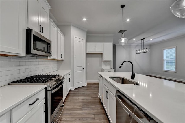 kitchen with appliances with stainless steel finishes, a sink, dark wood-type flooring, recessed lighting, and light countertops