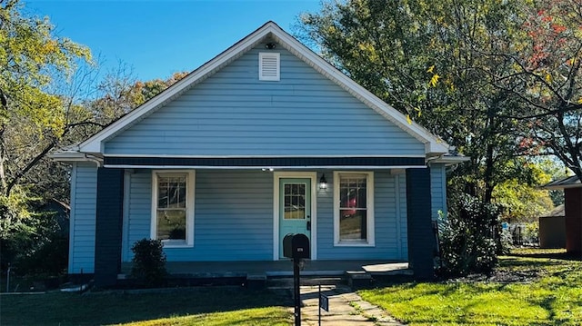 bungalow-style home with a front lawn and a porch