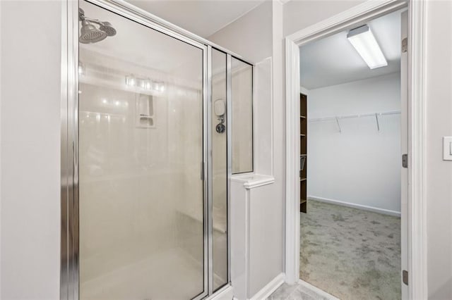 full bath featuring a stall shower and a walk in closet