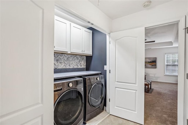 washroom with baseboards, cabinet space, washer and clothes dryer, and light colored carpet