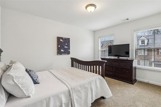 bedroom featuring baseboards, visible vents, and light carpet