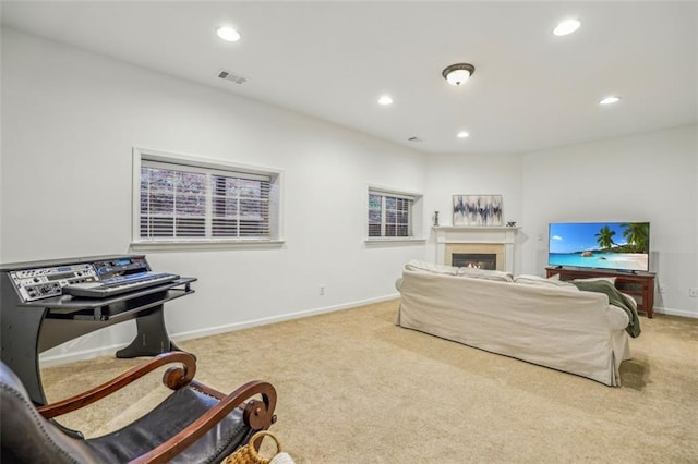 living area with a warm lit fireplace, recessed lighting, carpet, and visible vents