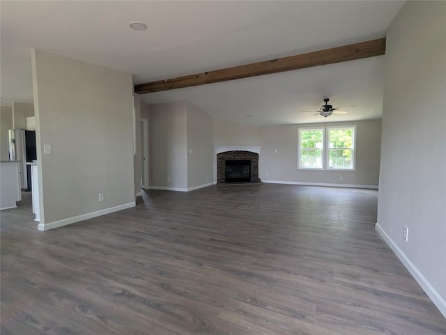 732 Five Points Rd, Buchanan, GA 30113 - unfurnished living room featuring wood finished floors, beamed ceiling, a fireplace, and a ceiling fan