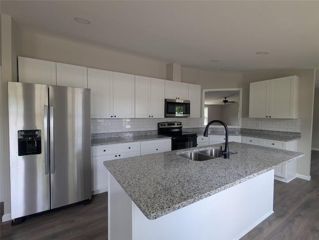 732 Five Points Rd, Buchanan, GA 30113 - kitchen featuring stainless steel appliances, white cabinetry, dark wood-type flooring, decorative backsplash, and light stone counters
