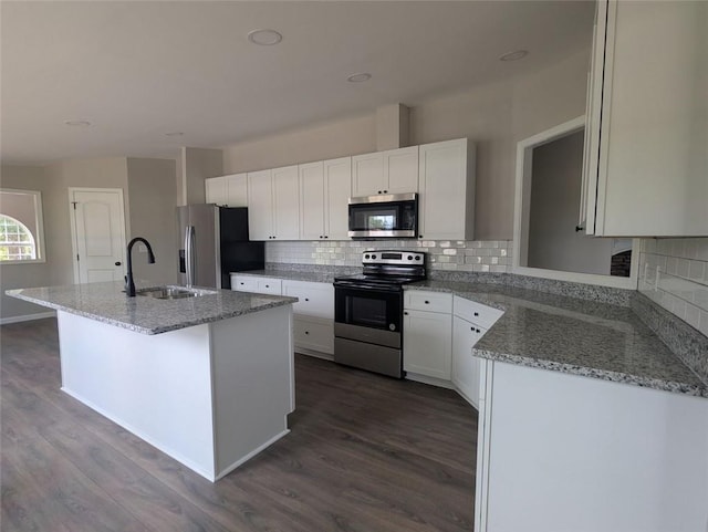 732 Five Points Rd, Buchanan, GA 30113 - kitchen with stainless steel appliances, dark wood finished floors, an island with sink, and tasteful backsplash