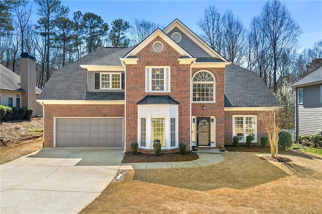 view of front of home featuring a front yard, driveway, a shingled roof, a garage, and brick siding