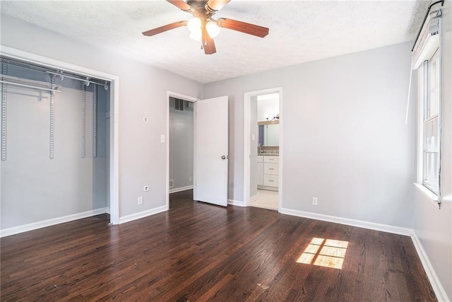 1663 Pounds Rd SW, Stone Mountain, GA 30087 - unfurnished bedroom featuring wood finished floors, baseboards, a closet, a textured ceiling, and a ceiling fan
